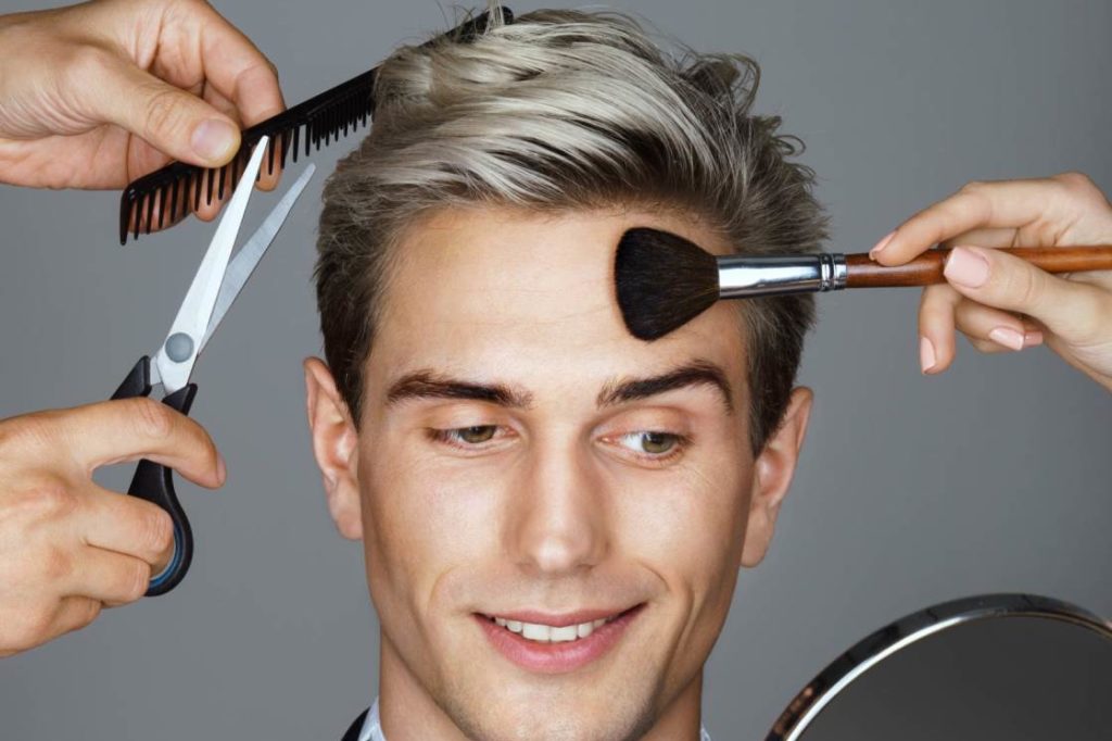 A young man being groomed with a range of grooming accessories